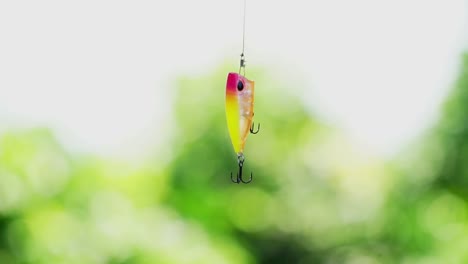 Close-up-shot-of-Artificial-fishing-lure-hanging-on-fishing-line