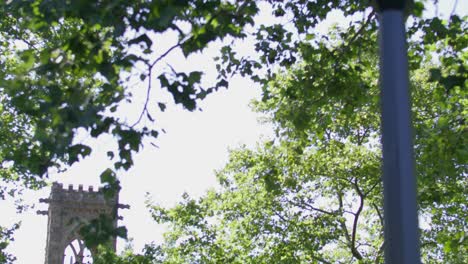 Close-up-of-a-street-light-with-pan-to-the-University-Chapel-and-students-walking-on-the-campus-of-the-University-of-Virginia-in-Charlottesville,-Virginia-in-slow-motion