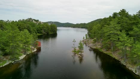 Vista-Aérea-De-Las-Cataratas-Whitefish-De-La-Isla-Manitoulin,-Lago-Tranquilo-Con-Una-Pequeña-Isla-Y-Pinos