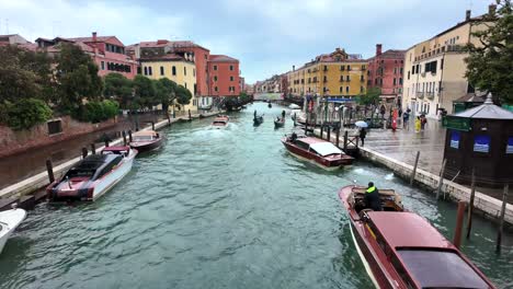 Movement-Of-People,-Gondolas-And-Motor-Boats-Through-A-Canal-In-Venice,-Italy