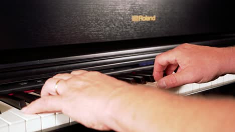 Close-up-of-a-man-configuring-black-roland-e-piano