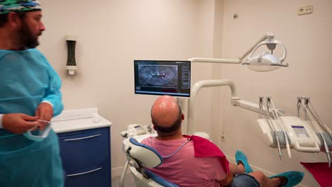 Male-dentist-doctor-explaining-an-oral-x-ray-to-his-patient-in-the-clinic