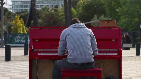 Street-performer-plays-piano-at-city-square-Place-Massena-in-Nice,-France