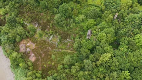 Aerial-reveal-of-Industrial-Revolution-ruins-of-old-tin-and-copper-mines,-blending-historical-structures-with-natural-surroundings,-Cornwall,-United-Kingdom