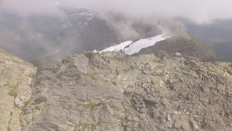 Hikers-take-a-break-at-the-top-of-a-narrow-ridge-summit-of-a-mountain