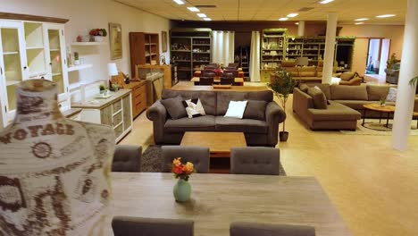 Wide-view-of-second-hand-furniture-inside-store-with-dining-tables,-sofas-and-dressers