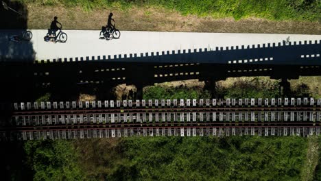 Cyclist-pass-an-old-wooden-rail-bridge-part-of-the-newly-constructed-historic-Northern-Rivers-Rail-Trail-in-Australia