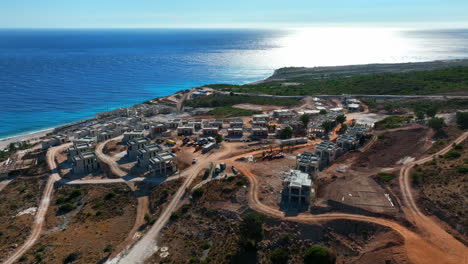 Aerial-tracking-shot-of-a-vacation-homes-under-construction,-summer-in-Albania