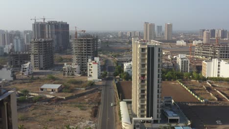 Drone-camera-moving-forward-showing-many-tenement-houses-and-large-farms