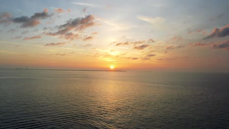 Una-Puesta-De-Sol-Serena-Sobre-El-Océano-En-Calma-En-Florida,-Con-Nubes-Suaves-Y-Un-Horizonte-Dorado-Que-Crean-Una-Escena-Pacífica.