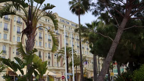 Fachada-Exterior-Del-Emblemático-Hotel-Carlton-De-Cannes-Con-Vegetación-En-Francia,-Vista-Estática-Lateral