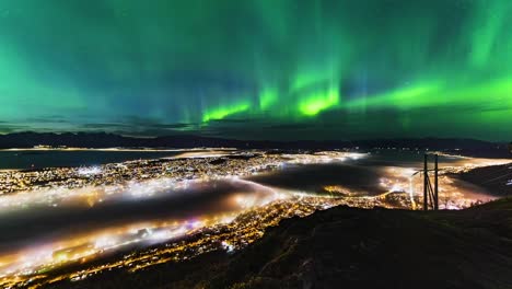 Time-lapse-of-aurora,-nortern-lights-with-city-Tromso,-Norway-in-front