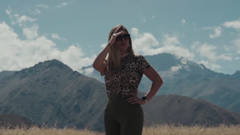 Frontwards-secure-woman-observes-landscape-with-mountains-in-the-background