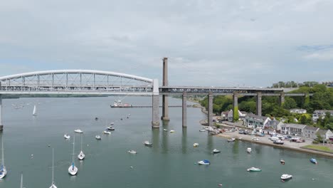 Drone-view-of-the-Royal-Albert-Bridge-and-Tamar-Bridge-from-Devon-to-Cornwall,-UK,-showcasing-river-and-bridges