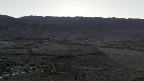 Drone-Volando-Sobre-El-Cerro-De-La-Cruz-Al-Atardecer,-Tafi-Del-Valle,-Tucumán,-Argentina,-Cruz-En-La-Cima-Del-Pueblo,-Rodeada-De-Montañas