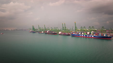 Eine-Weite-Luftaufnahme-Zeigt-Ein-Riesiges,-Beladenes-Containerschiff,-Das-Im-Hafen-Von-Singapur-Angedockt-Ist