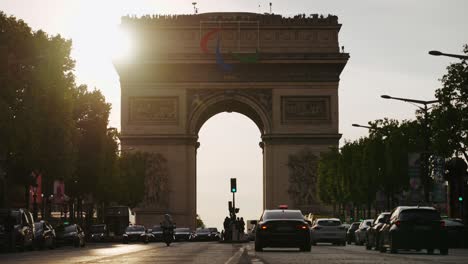 Juegos-Olímpicos-De-París-2024,-Arco-Del-Triunfo,-Hora-Dorada-Con-Tráfico-En-Primer-Plano