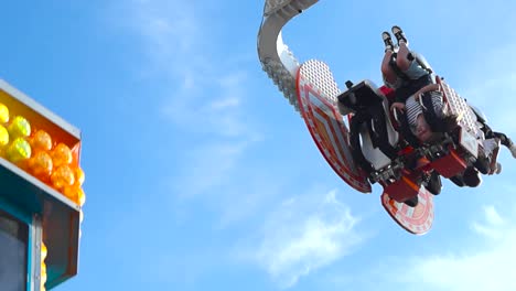 Beautiful-slow-motion-footage-of-two-people-having-fun-on-an-amusement-park-ride-or-attraction-during-the-summer-time-while-being-swung-on-their-hair-moving-by-the-wind-cinematically