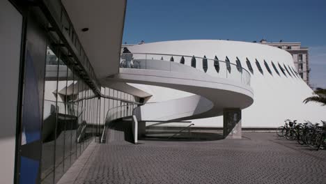 Un-Ciclista-Sube-Por-La-Rampa-Del-Futurista-Volcán-Oscar-Niemeyer-En-Le-Havre,-Francia