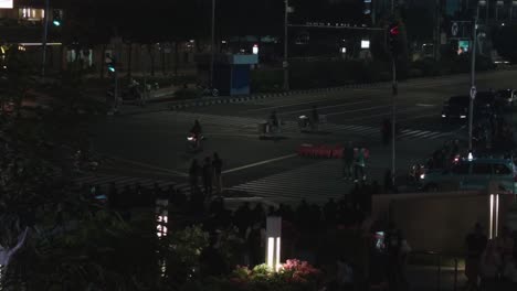 Busy-crossroad,-full-of-people,-cars-and-motorcycles-at-night,-evening-in-Indonesia,-static-shot-and-time-lapse