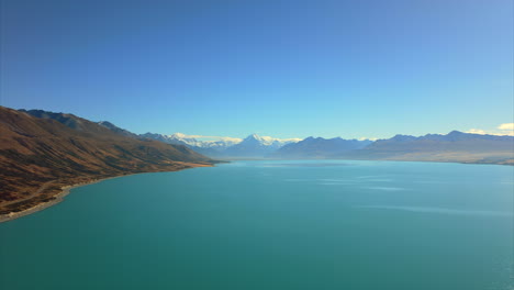 Lake-Pukaki-alpine-lake-in-the-Mackenzie-Basin,-New-Zealand-with-Mont-Cook-in-the-background---aerial-flyover