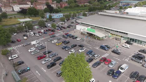 Aerial-orbital-view-of-Asda-superstore,-featuring-the-parking-lot,-store-building,-and-surrounding-infrastructure,-Bridgwater,-United-Kingdom,-July-2024