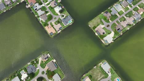 Aerial-tilt-up-shot-of-luxury-neighborhood-surrounded-by-waters-in-Cape-Coral,-Florida,-USA