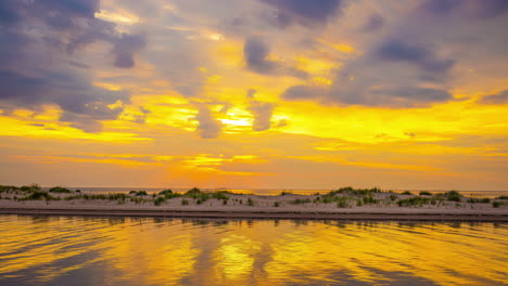 Timelapse-of-a-yellow-sunset-with-clouds-on-the-beach-with-dunes