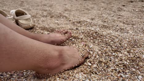 Los-Pies-Descalzos-Se-Sumergen-En-La-Arena-En-La-Playa-De-Karadag-En-Crimea,-Rusia.