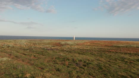 Aerial-Approach-to-Lighthouse-on-Island-at-Sunset