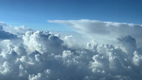 Vista-Del-Piloto-Volando-En-Un-Cielo-Azul-Lleno-De-Nubes-Tormentosas-Tomada-Desde-La-Cabina-De-Un-Avión-A-Nivel-De-Crucero