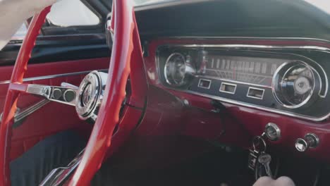 Steering-a-vintage-sixty-five-Mustang-down-the-road-while-shifting-gears-on-a-sunny-day