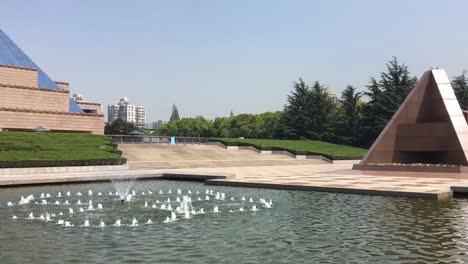 Pirámides,-Fuente-En-El-Estanque-De-Agua-En-El-Parque-De-Los-Jardines-Longhua-Cerca-Del-Monumento-A-Los-Mártires-En-Shanghai,-China,-Toma-Panorámica