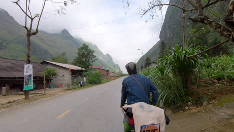 Hombre-Asiático-Paseando-En-Bicicleta-Por-Un-Pequeño-Pueblo-De-Vietnam