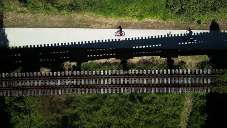 Radfahrer-Passieren-Eine-Alte-Hölzerne-Eisenbahnbrücke,-Die-Teil-Des-Neu-Errichteten-Historischen-Northern-Rivers-Rail-Tourism-Trail-In-Australien-Ist