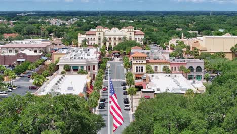 Bandera-Estadounidense-En-El-Centro-De-The-Villages,-Florida,-Rodeada-De-Edificios-Y-árboles.