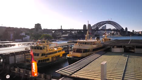 Wide-view-of-the-Sydney-Harbour-Bridge,-Circular-Quay-and-harbour-ferries-on-a-sunny-day