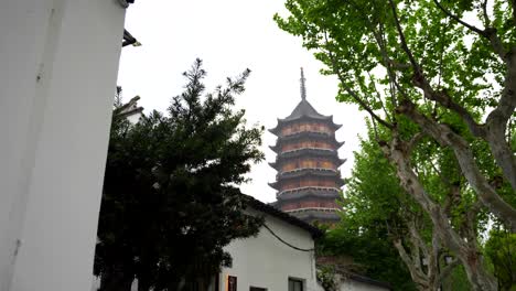 North-Temple-Pagoda-rises-behind-old-houses-and-lush-trees-in-Suzhou-city-center,-China