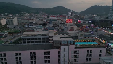 Toma-Aérea-Del-Paisaje-Urbano-Junto-A-La-Playa-De-Patong-Al-Atardecer-En-Phuket,-Tailandia