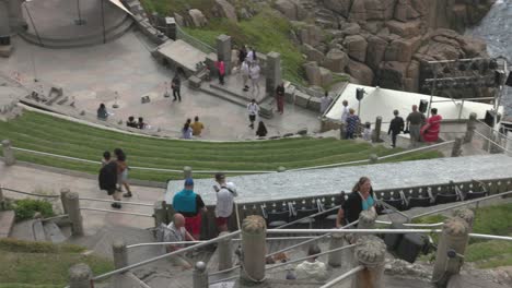 Panning-shot-of-tourists-sitting-and-admiring-the-beautiful-Minack-Theater