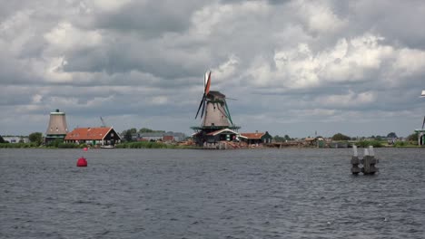 Windmills-of-Zaanse-Schans,-timeless-tableau,-blades-turn-against-Dutch-sky