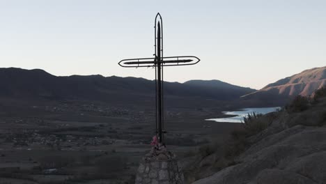 Close-shot-of-drone-flying-around-Cerro-de-La-Cruz-at,-Tucumán,-Tafi-del-Valle,-Argentina,-moving-round-cross,-at-the-top-and-Dique-la-Angostura-reservoir,-Dique-la-Pueblo-Mollar,-in-middle-of-andes