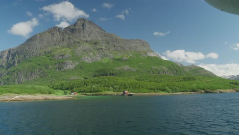 Fähre-überquert-Ein-Ruhiges-Meer-Mit-Einem-Malerischen-Blick-Auf-Die-Berge-Und-Einem-Klaren-Blauen-Himmel