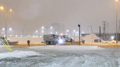 Camiones-De-Maquinaria-Pesada-Nivelando-Nieve-Siguiendo-A-Cada-Uno-En-La-Agitada-Noche-Urbana