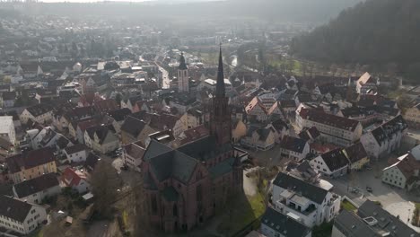 Drone-orbits-Nagold-city-church-in-red-brick-architecture,-religious-swabian-place-of-prayer