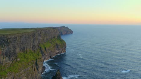 Aerial-tilt-down-captures-the-Cliffs-of-Moher-bathed-in-beautiful-sunset-light