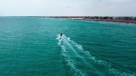 Das-Bild-Ist-Eine-Luftaufnahme-Eines-Strandes-Mit-Kristallklarem-Wasser-In-Mahdia,-Wo-Die-Menschen-Verschiedene-Aktivitäten-Genießen