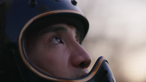 Retrato-De-Un-Motociclista-Masculino-Que-Lleva-Un-Casco-Sin-Visera,-Abre-Los-Ojos-Y-Mira-Hacia-El-Cielo.