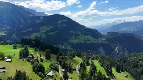 Scardanal,-Suiza,-Con-Exuberantes-Montañas-Verdes-Y-Casas-Dispersas,-Vista-Aérea