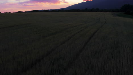 Drone-shot-of-Sunset-in-Gerlachov-village-agricultural-field-with-mountain-range-in-background-in-Tatransky-region,-High-Tatras,-Gerlachovsky-stit-mountain